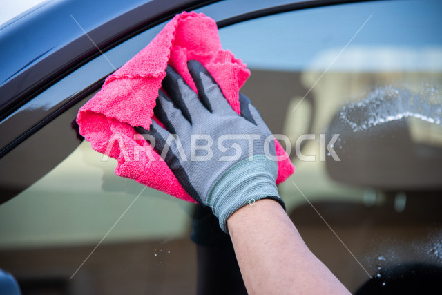 احدى الأشخاص العالمين يعمل لدى شركة متنقلة لغسيل السيارات وتلميعها في السعودية ، استخدام تقنيات لتنظيف و صيانه و تلميع السيارات ، استخدام مستحضرات ذات فعالية عالية ،التلميع الخارجي للسيارات