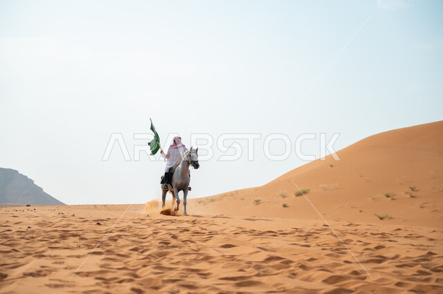 الفخر والتباهي بالإنتماء للمملكة، شغف الفروسية وممارسة هواية ركوب الخيل، رجل عربي خليجي سعودي يمتطي حصان عربي أصيل ويرفع علم السعودية، العيد الوطني السعودي، اليوم الوطني لتوحيد المملكة 8 ربيع الأول، يوم العلم 11 مارس، حب وعشق الفرس السعودي
