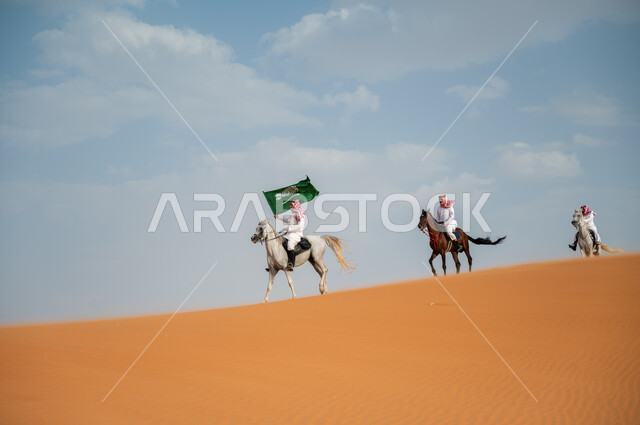 الاحتفال بيوم العلم السعودي 11 مارس، قوة وسرعة الخيل السعودي, مشاركة فعاليات ركوب الخيل في العيد الوطني، هواية امتطاء الجياد في الصحراء، إحياء ذكرى اليوم الوطني 8 ربيع الأول، مجموعة رجال عرب خليجيون سعوديون يتسابقون على ظهر الاحصنة ويرفعون علم المملكة