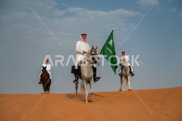 The place of the horse in the hearts of the people of the Kingdom, celebrating the anniversary of the National Day, National Day, September 23, commemorating the Saudi Flag Day, March 11, Saudi Gulf Arab knights riding horses in the desert and raising the Kingdom’s flag, the connection of horses to Saudi history.