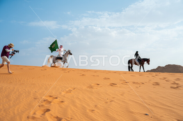 Participation of men and women in celebrating Saudi national occasions, deepening loyalty to the homeland by celebrating the anniversary of National Day September 23, the connection of horses to the heritage and history of the Kingdom, two Saudi Gulf Arab knights and knights riding horses in the desert, Saudi Flag Day March 11