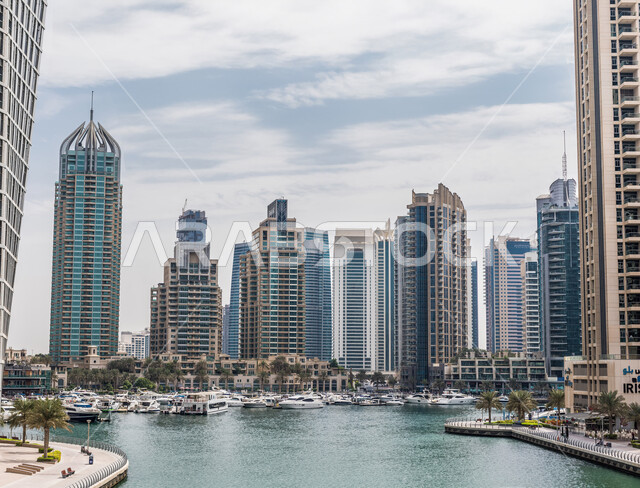 الواجهة البحرية لإمارة دبي في وضح النهار, منظر السماء والسحب البيضاء في مرسى دبي في الإمارات العربية المتحدة, أماكن ومعالم ساحلية سياحية مشهورة, الأبراج وناطحات السحاب المطلة على مرفأ اليخوت