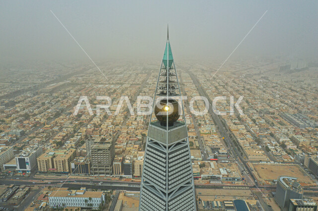 A close-up of the Al-Faisaliah Tower in the Olaya district in the city of Riyadh in broad daylight, famous tourist attractions in the Kingdom of Saudi Arabia, the architectural art of the towers and skyscrapers, a tower with a pyramidal design with curved