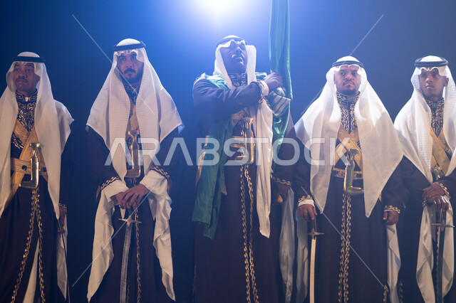 فرقة عروض الفلكلور التراثي في ذكرى العيد الوطني في 8 ربيع الاول، الاحتفال بيوم العلم 11 مارس, ارتداء زي العرضة النجدية الشعبية، الرقص الشعبي بالسيوف والأهازيج والاحتفالات في المناسبات الوطنية، اليوم الوطني السعودي، خلفية سوداء مع إضاءة بيضاء