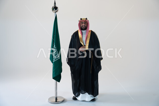 مؤسس الدوله السعوديه الاولى الامام محمد بن سعود، تأسيس المملكة العربية السعودية  1727 م، ذكرى اليوم الوطني السعودي 23 سبتمبر، يوم العلم 11 مارس، بورتريه لرجل عربي خليجي سعودي يرتدي البشت والشماغ يقف بجانب البيرق، صورة الجسم بالطول الكامل، خلفية بيضاء