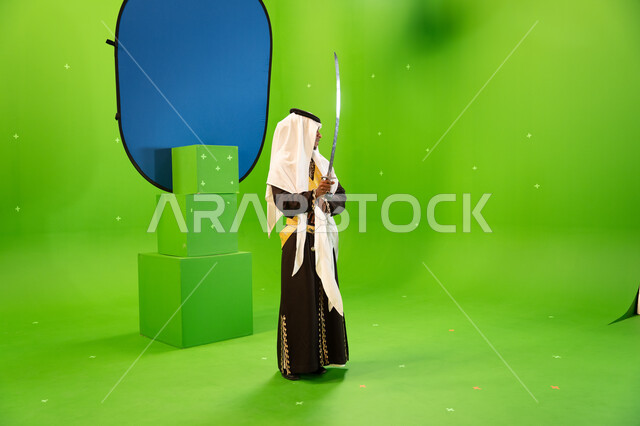 إظهار إرث المنطقة الجنوبية, الاحتفال بذكرى تأسيس الدولة السعودية الأولى 22 شباط بأداء العرضة النجدية, استخدام السيوف في الرقص الشعبي، ارتداء أزياء المناسبات الوطنية، فنون وعروض الفلكلور التراثي السعودي، صورة الجسم بالطول الكامل، خلفيه خضراء و زرقاء ،كروما