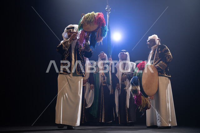 حب الوطن والانتماء إليه, فرقة عروض الفلكلور التراثي في العيد الوطني في 23 سبتمبر، الاحتفال بيوم العلم السعودي في 11 مارس, ارتداء زي العرضة النجدية الشعبية، الرقص الشعبي والاحتفالات في المناسبات الوطنية, خلفية سوداء مع إضاءة بيضاء
