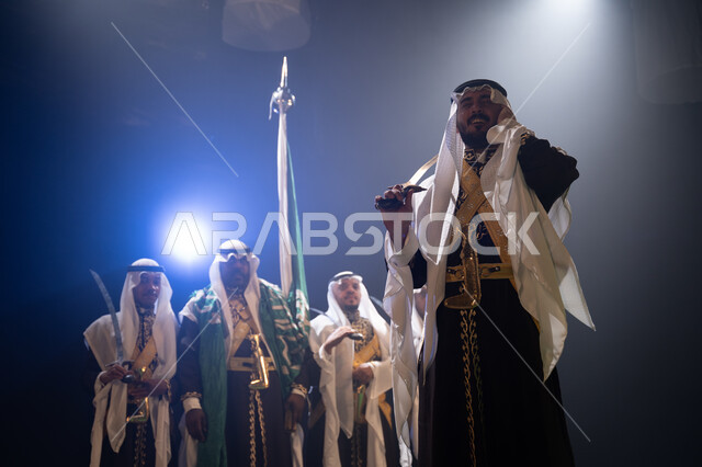 احتفالات وأهازيج في المناسبات والأعياد الوطنية، الرقص الشعبي بالسيوف في العرضة النجدية، ارتداء زي الدقلة والفرميلة الشعبية، فرقة عروض الفلكلور التراثي في العيد الوطني في 23 سبتمبر، الاحتفال بيوم العلم 11 مارس, خلفية سوداء مع إضاءة بيضاء