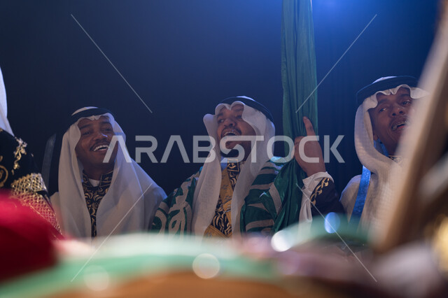 الاحتفال بيوم العلم في 11 مارس, التعبير عن حب الوطن والانتماء إليه, الأهازيج والاحتفالات في اليوم الوطني في 23 سبتمبر, فعاليات وأجواء سعودية, فرقة عروض الفلكلور التراثي في المناسبات الوطنية, ارتداء زي العرضة النجدية الشعبية, خلفية سوداء مع إضاءة بيضاء