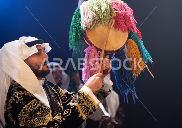 المناسبات والأعياد الوطنية, صورة من الجانب لرجل عربي خليجي سعودي يرتدي زي العرضة النجدية التقليدي يحتفل باليوم الوطني في 23 سبتمبر, إظهار حب الوطن والانتماء إليه, يوم العلم السعودي في 11 مارس, عروض فرقة الفلكلور التراثي, خلفية سوداء