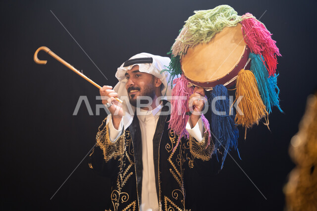 الأعياد والمناسبات الوطنية, النظر إلى شيء ما, صورة مقربة لرجل عربي خليجي سعودي يرتدي زي العرضة النجدية التقليدي يحتفل باليوم الوطني في 23 سبتمبر, إظهار حب الوطن والانتماء إليه, يوم العلم السعودي في 11 مارس, عروض فرقة الفلكلور التراثي, خلفية سوداء