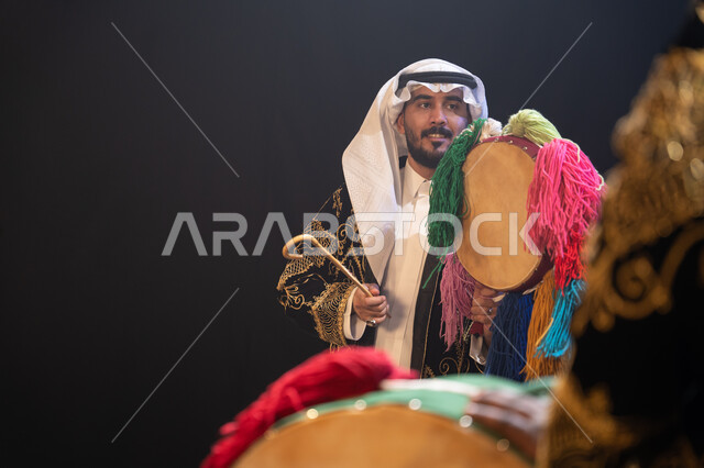 النظر إلى شيء ما, صورة مقربة لرجل عربي خليجي سعودي يرتدي زي العرضة النجدية التقليدي يحتفل باليوم الوطني في 23 سبتمبر, إظهار حب الوطن والانتماء إليه, يوم العلم السعودي في 11 مارس, الأعياد والمناسبات الوطنية, عروض فرقة الفلكلور التراثي, خلفية سوداء