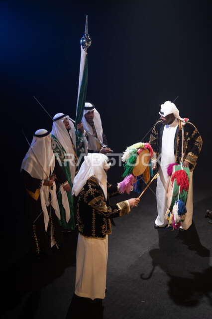 صورة من الأعلى لفرقة عروض الفلكلور التراثي تحتفل في يوم العلم في 11 مارس, المناسبات والفعاليات الوطنية, ارتداء زي الدقلة والفرميلة الشعبية, استذكار اليوم الوطني في 23 سبتمبر, الرقص الشعبي والأهازيج والاحتفالات للعرضة النجدية, خلفية سوداء