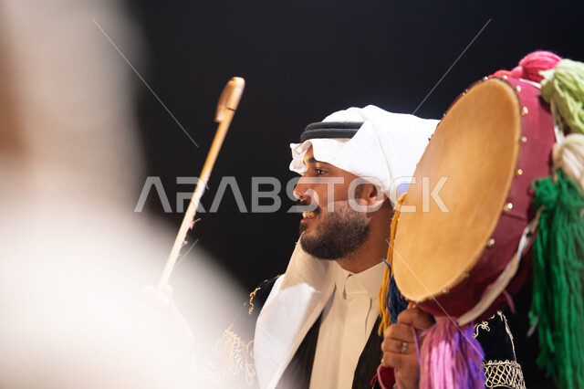 Participation of traditional folklore groups in national celebrations and events, close-up photo from the side of a Saudi Gulf Arab man celebrating National Day on September 23, showing love for the homeland and belonging to it, Saudi Flag Day on March 11
