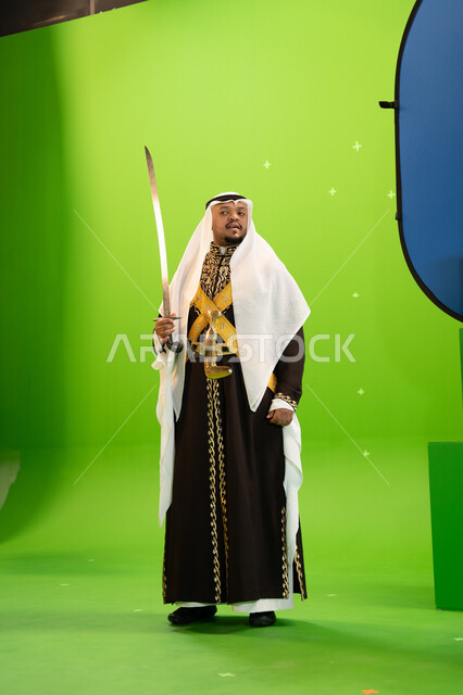 الاحتفال بذكرى تأسيس الدوله السعودية الاولى 22 شباط بأداء العرضة النجدية, عروض الفلكلور التاريخي السعودي، إظهار إرث المنطقة الجنوبية, استخدام السيوف في الرقص الشعبي، ارتداء أزياء المناسبات الوطنية، صورة الجسم بالطول الكامل، خلفيه خضراء و زرقاء ،كروما