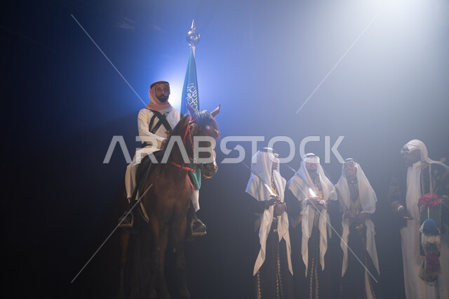 عروض فرقة الفلكلور التراثي في اليوم الوطني 23 سبتمبر, يوم العلم السعودي 11 مارس, مشاركة الأحصنة في الاحتفالات الوطنية, فارس عربي خليجي سعودي يمتطي فرسة ويمسك علم المملكة بفخر واحترام, أنشطة وفعاليات ركوب الخيل في الأعياد السعودية, ارتداء زي العرضة النجدية