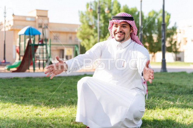 فتاه جميلة مصابة بملازمة داون تقضي وقتها في نزهه مع والدها بالمنتزه ، اب سعودي خليجي يلعب مع ابنته في الهواء الطلق ، أصحاب الهمم ، ذوي الاحتياجات الخاصة