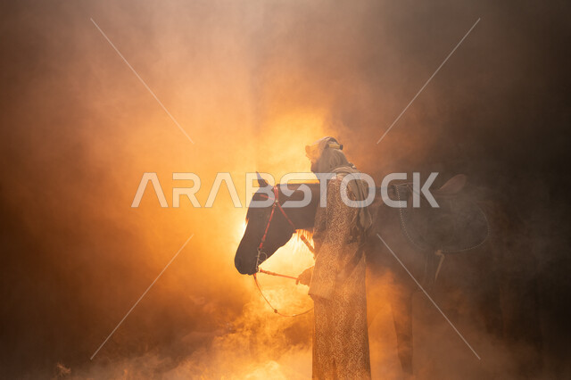 ذكرى تأسيس الدولة السعودية الأولى 1727 م، يوم التأسيس السعودي 22 فبراير، حب الفروسية والشغف في تربية الجياد، ارتداء أزياء المناسبات والأعياد الوطنية، صورة جانبية لرجل خليجي يرتدي الدقلة والغترة يداعب خيله العربي الأصيل، خلفية ضبابية مع إضاءة صفراء. 