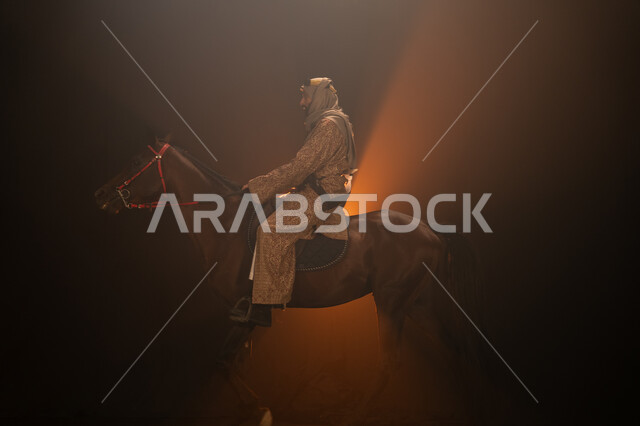  ذكرى تأسيس الدولة السعودية الأولى 1727 م، يوم التأسيس السعودي 22 فبراير، ممارسة هواية ركوب الأحصنة، ارتداء أزياء المناسبات والأعياد الوطنية، صورة جانبية لرجل خليجي يرتدي الدقلة والغترة يمتطي فرسه البني العربي الأصيل، خلفية ضبابية مع إضاءة صفراء. 