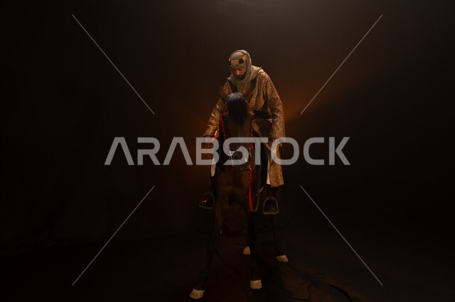 الاحتفال مع الخيل بذكرى تأسيس الدولة السعودية الأولى 1727 م، يوم التأسيس السعودي 22 فبراير، ممارسة هواية ركوب الأحصنة، ارتداء أزياء المناسبات والأعياد الوطنية، رجل خليجي يرتدي الدقلة والغترة يمتطي فرسه البني العربي الأصيل، خلفية ضبابية مع إضاءة صفراء. 