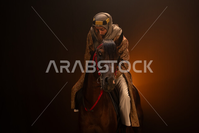 الاحتفال مع الخيل بذكرى تأسيس الدولة السعودية الأولى 1727 م، يوم التأسيس السعودي 22 فبراير، ممارسة هواية ركوب الأحصنة، ارتداء أزياء المناسبات والأعياد الوطنية، رجل خليجي يرتدي الدقلة والغترة يمتطي فرسه البني العربي الأصيل، خلفية ضبابية مع إضاءة صفراء. 