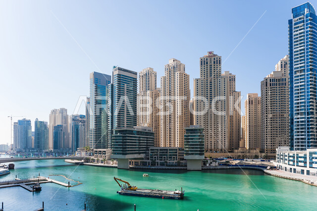 The architectural engineering art of the towers and skyscrapers overlooking the artificial sea in the city of Dubai, the urban growth and development of buildings and facilities in the Emirates, the famous landmarks of Dubai, the transport of machinery an