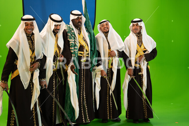 ذكرى اليوم الوطني السعودي في 23 سبتمبر، القاء القصائد الحماسيه والشعر السعودي والغناء، المهرجانات الشعبية والرقص بالسيوف والأهازيج في المناسبات والأعياد الوطنية، ارتداء ازياء العرضة النجدية، صورة الجسم بالطول الكامل، خلفية خضراء وزرقاء، كروما