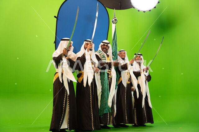 الرقص الشعبي في المناسبات الوطنيه والاعياد، استخدام السيف بحركات منتظمه في العرضة السعوديه ،ذكرى اليوم الوطني السعودي في 23 سبتمبر، ايماءات الضحك والسرور ، الغناء والقاء القصائد الحماسيه والشعر السعودي، صورة االجسم بالطول الكامل، خلفية خضراء وزرقاء، كروما