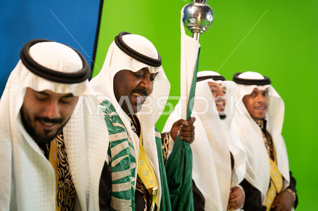 عروض التراث الشعبي في ذكرى اليوم الوطني السعودي في 23 سبتمبر، المهرجانات الشعبية والرقص بالسيوف والأهازيج في الأعياد الوطنية، ارتداء ازياء العرضة النجدية، العيد الوطني السعودي ، الاحتفال بيوم العلم 11 مارس بايماءات السعاده، خلفية خضراء وزرقاء، كروما