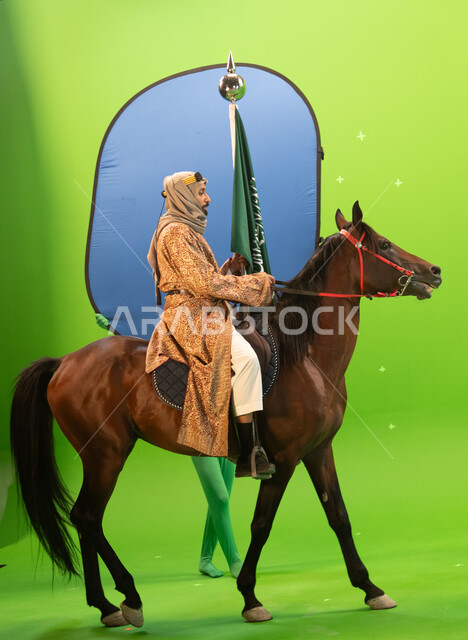 ذكرى توحيد المملكة العربية السعودية 1727، مؤسس الدوله السعوديه الاولى الامام محمد بن سعود، شغف الفروسية وتربية الجياد، الاحتفال بيوم التأسيس في 22 فبراير، بورتريه لرجل عربي خليجي سعودي يرتدي الغترة والدقلة يمتطي حصان بني اصيل، خلفية خضراء وزرقاء، كروما