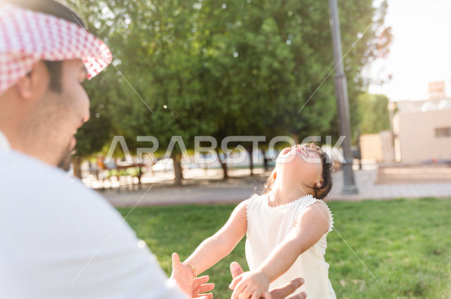 فتاه جميلة مصابة بملازمة داون تقضي وقتها في نزهه مع والدها بالمنتزه ، اب سعودي خليجي يلعب مع ابنته في الهواء الطلق ، أصحاب الهمم ، ذوي الاحتياجات الخاصة