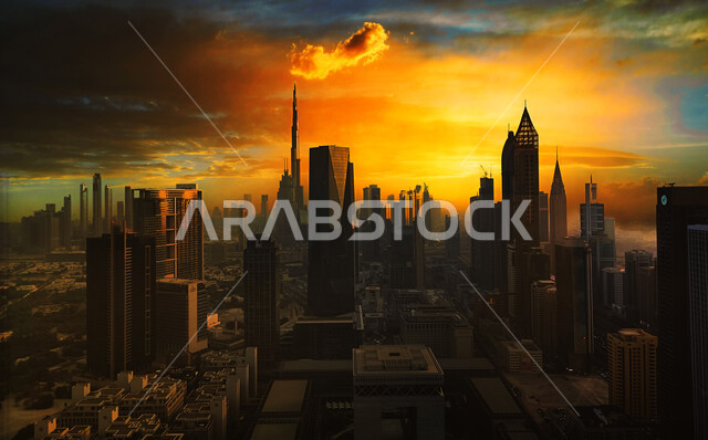 النمو والتطور العمراني للبنية التحتية الإماراتية، السماء الملبدة بالغيوم وقت غروب الشمس، صورة بانورامية للأبراج وناطحات السحاب في مدينة دبي، الفن الهندسي المعماري للمباني والمنشآت في الإمارات، معالم دبي المشهورة، أماكن سياحية في الإمارات