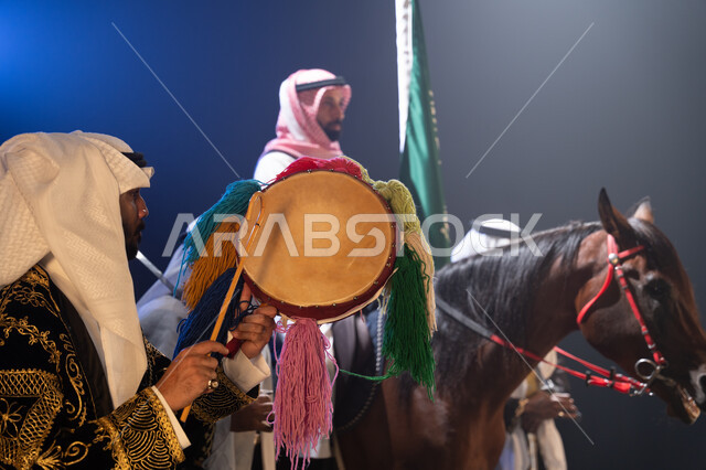 عروض فرقة الفلكلور التراثي في يوم العلم 11 مارس, الاحتفال مع الأحصنة في اليوم الوطني في 23 سبتمبر في وضح الليل, نشر حب الخيل بين أبناء الوطن, رجل يمتطي خيل عربي بني أصيل, حب الفروسية وشغف الاهتمام بها, الأعياد والمناسبات الوطنية, ارتداء زي العرضة النجدية.