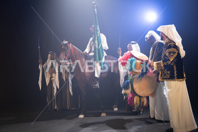 مشاركة الأحصنة في الاحتفالات الوطنية, فارس عربي خليجي سعودي يمتطي فرسه ويمسك علم المملكة بفخر واحترام, أنشطة وفعاليات ركوب الخيل في الأعياد السعودية, عروض فرقة الفلكلور التراثي في اليوم الوطني 23 سبتمبر, يوم العلم السعودي 11 مارس, ارتداء زي العرضة النجدية