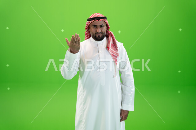 اشارات يدين تدل على التوبيخ، طلب التوقف عن فعل الأخطاء، رجل عربي خليجي سعودي يرتدي الثوب والشماغ التقليدي يرفع يده الى الأعلى بإيماءات الغضب، خلفية خضراء، كروما