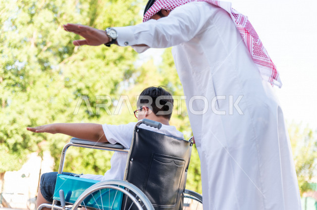 ولد جميل سعوي خليجي مصاب بملازمة داون يقضي وقته في نزهه مع والده  بالمنتزه ، طفل مقعد على كرسي متحرك يستمتع بالهواء الطلق ، أصحاب الهمم ، ذوي الاحتياجات الخاصة ، اعاقة حركية