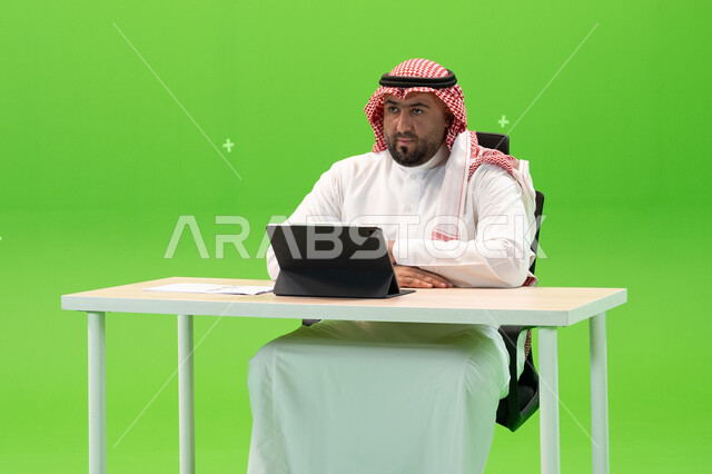 Thinking, absent-mindedness, and looking at something, the concept of integrating work with technology and technology, a close-up portrait of a Saudi Gulf Arab man wearing traditional Saudi clothing, completing work tasks using a tablet, Saudi companies a