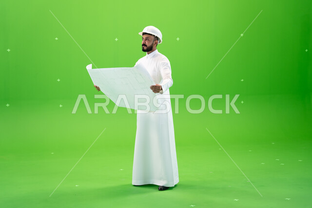 مفهوم الهندسة والإنشاءات المعمارية, تقدم وتطور السعودية على يد سواعد أبناء الوطن, بورتريه لمهندس عربي خليجي سعودي يرتدي قبعة الحماية في موقع العمل, تنمية وتطوير المجال الهندسي, الاهتمام بشؤون العمل, صورة الجسم بالطول الكامل, خلفية خضراء, كروما