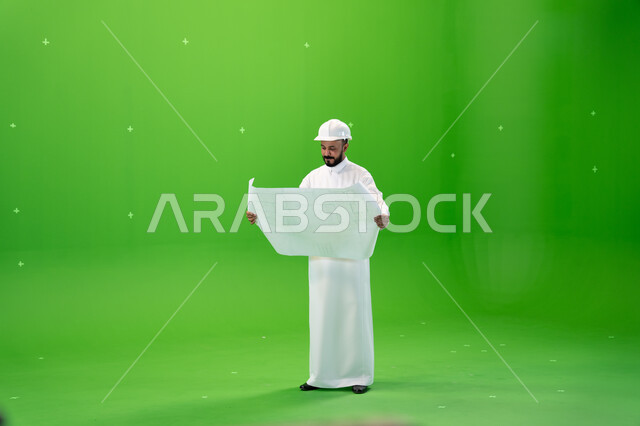 الوظائف الهندسية في الشركات السعودية, الاشراف والتدقيق على العمل, بورتريه لمهندس عربي خليجي سعودي يرتدي قبعة الحماية يقف في موقع العمل, مفهوم الهندسة والإنشاءات, الإعمار بسواعد أبناء الوطن, صورة الجسم بالطول الكامل, خلفية خضراء, كروما