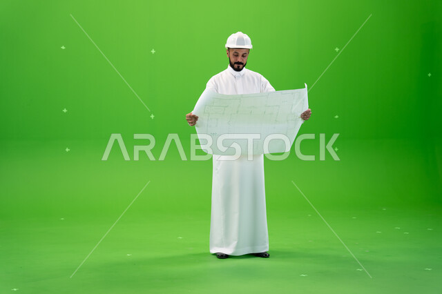 مفهوم الهندسة والإنشاءات, الاشراف والتدقيق على العمل, بورتريه لمهندس عربي خليجي سعودي يرتدي قبعة الحماية يقف في موقع العمل, الوظائف الهندسية في الشركات السعودية, الإعمار بسواعد أبناء الوطن, صورة الجسم بالطول الكامل, خلفية خضراء, كروما