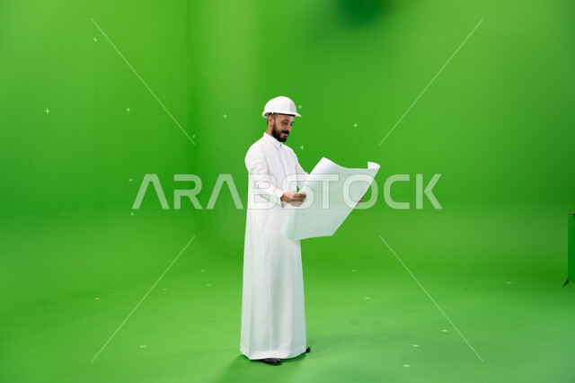 الوظائف الهندسية في الشركات السعودية, الاشراف والتدقيق على العمل, بورتريه لمهندس عربي خليجي سعودي يرتدي قبعة الحماية يقف في موقع العمل, مفهوم الهندسة والإنشاءات, الإعمار بسواعد أبناء الوطن, صورة الجسم بالطول الكامل, خلفية خضراء, كروما