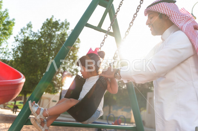 فتاه جميلة مصابة بملازمة داون تقضي وقتها في نزهه مع والدها بالمنتزه ، اب سعودي خليجي يأرجح ابنته على  لعبة الارجوحة ، أصحاب الهمم ، ذوي الاحتياجات الخاصة