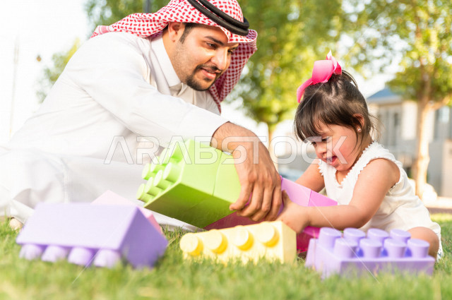 فتاه جميلة مصابة بملازمة داون تقضي وقتها في نزهه مع والدها بالمنتزه ، اب سعودي خليجي يلعب مع ابنته في الهواء الطلق ، أصحاب الهمم ، ذوي الاحتياجات الخاصة