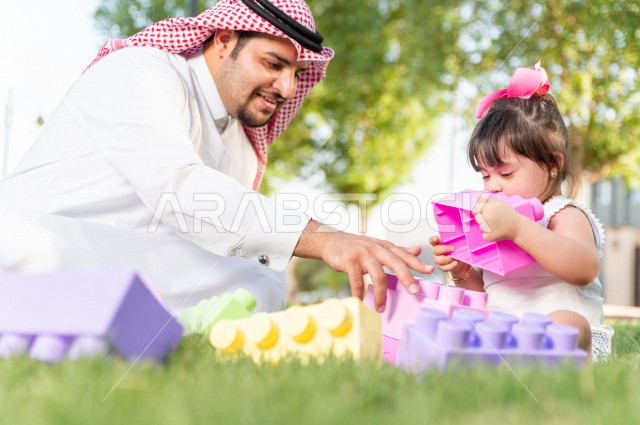 فتاه جميلة مصابة بملازمة داون تقضي وقتها في نزهه مع والدها بالمنتزه ، اب سعودي خليجي يلعب مع ابنته في الهواء الطلق ، أصحاب الهمم ، ذوي الاحتياجات الخاصة