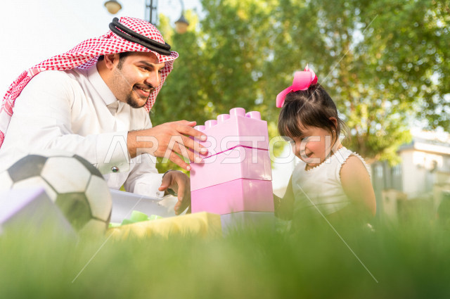 فتاه جميلة مصابة بملازمة داون تقضي وقتها في نزهه مع والدها بالمنتزه ، اب سعودي خليجي يلعب مع ابنته في الهواء الطلق ، أصحاب الهمم ، ذوي الاحتياجات الخاصة
