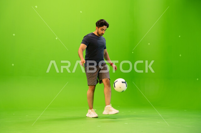 لاعب كرة قدم محترف يمارس تمارين الاحماء و الاستعداد، انشطة شبابيه ترفيهيه، المنتخب الوطني السعودي لكرة القدم، رجل عربي خليجي سعودي يرتدي الزي الرياضي يقوم بالتدريب و التجهز والتحضير لبدء المباراة، صورة الجسم بالطول الكامل، خلفية خضراء، كروما
