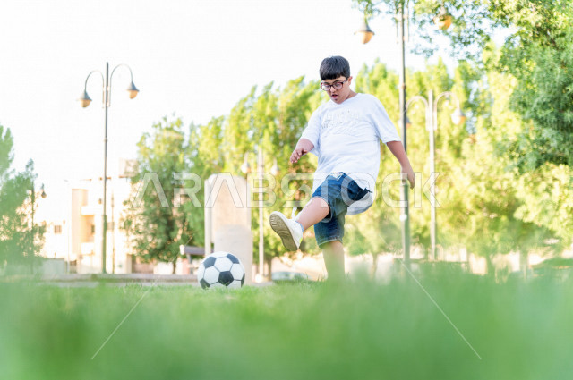 ولد سعوي خليجي مصاب بملازمة داون يقضي وقته في نزهه بالمنتزه ، يستمتع بلعب كرة القدم ، أصحاب الهمم ، ذوي الاحتياجات الخاصة