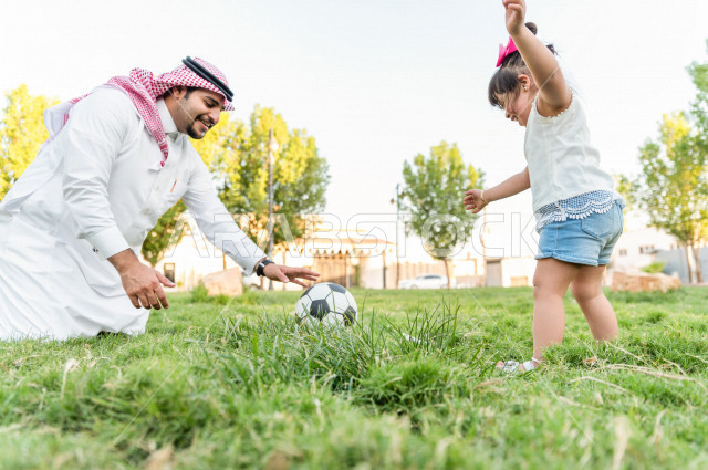 فتاه جميلة مصابة بملازمة داون تقضي وقتها في نزهه مع والدها بالمنتزه ، اب سعودي خليجي يلعب مع ابنته بكرة القدم ، أصحاب الهمم ، ذوي الاحتياجات الخاصة