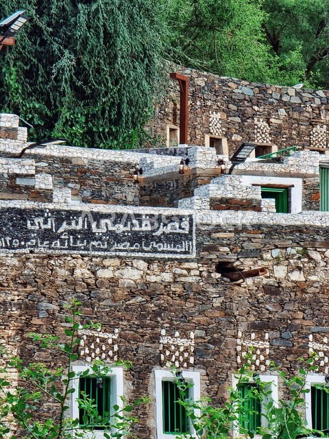 الفن الهندسي المعماري على الطراز العربي القديم لقصر قديمي التراثي، الأشجار والنباتات الخضراء في قرية رجال ألمع، المباني الأثرية التاريخية القديمة، معالم مدينة عسير التراثية، أماكن سياحية مشهورة في المملكة العربية السعودية