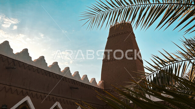 صورة مقربة لسعف النخيل الأخضر، التصميم المعماري العربي القديم لمأذنة طينية لمسجد قرية أشيقر التراثية، الفن الهندسي المعماري للمباني الأثرية في محافظة الشقراء، المعالم التاريخية القديمة في مدينة الرياض، أماكن سياحية مشهورة في السعودية